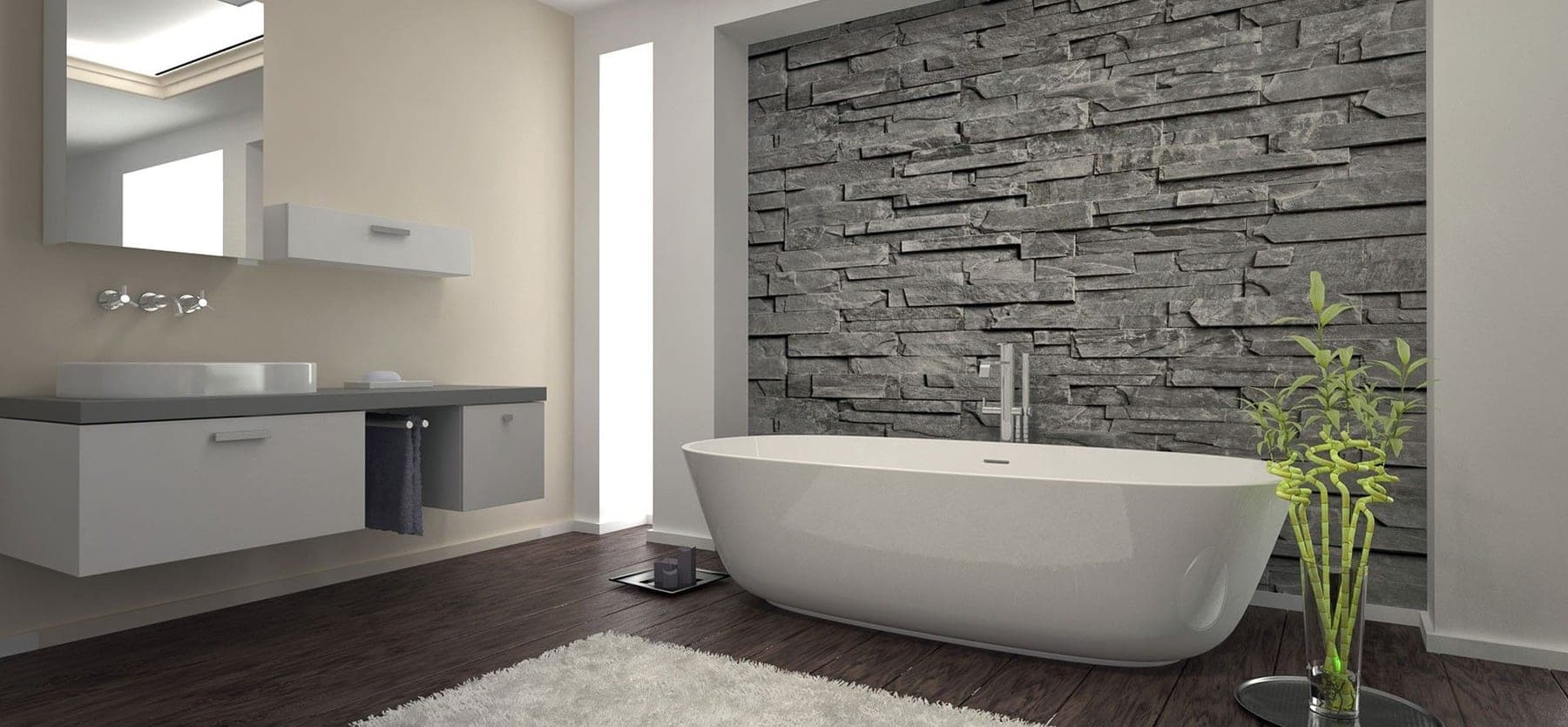 Freistehende Badewanne vor einer Decorstein-Wand aus geschichtetem Naturstein
