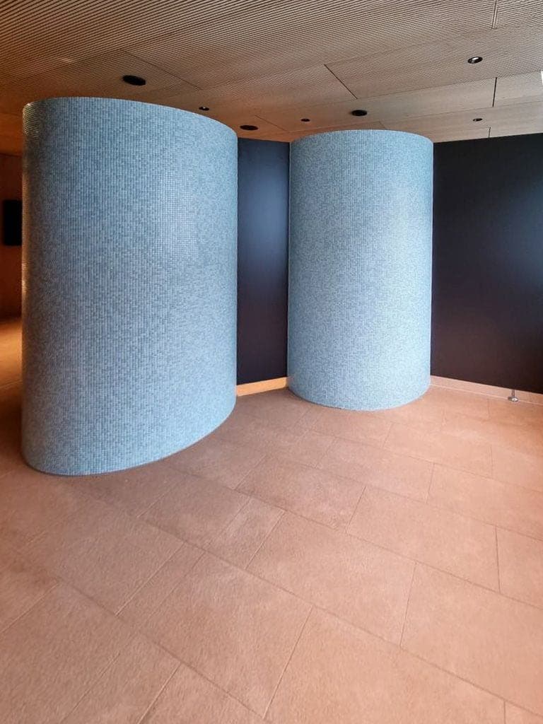 Geschwungene Mosaiksäulen aus hellblauen Glasmosaiksteinen im Wellnessbereich
