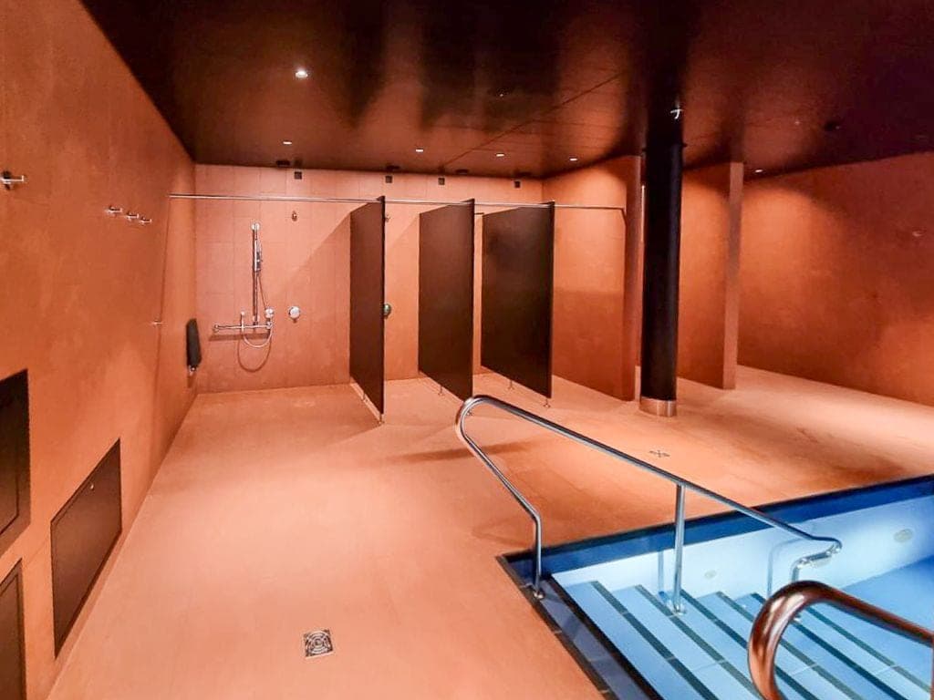 Wellnessbereich mit Poollandschaft, Natursteinwänden und dunklen Säulen